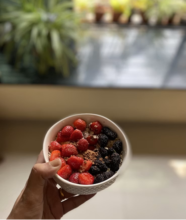 Hand holding a berry oatmeal bowl